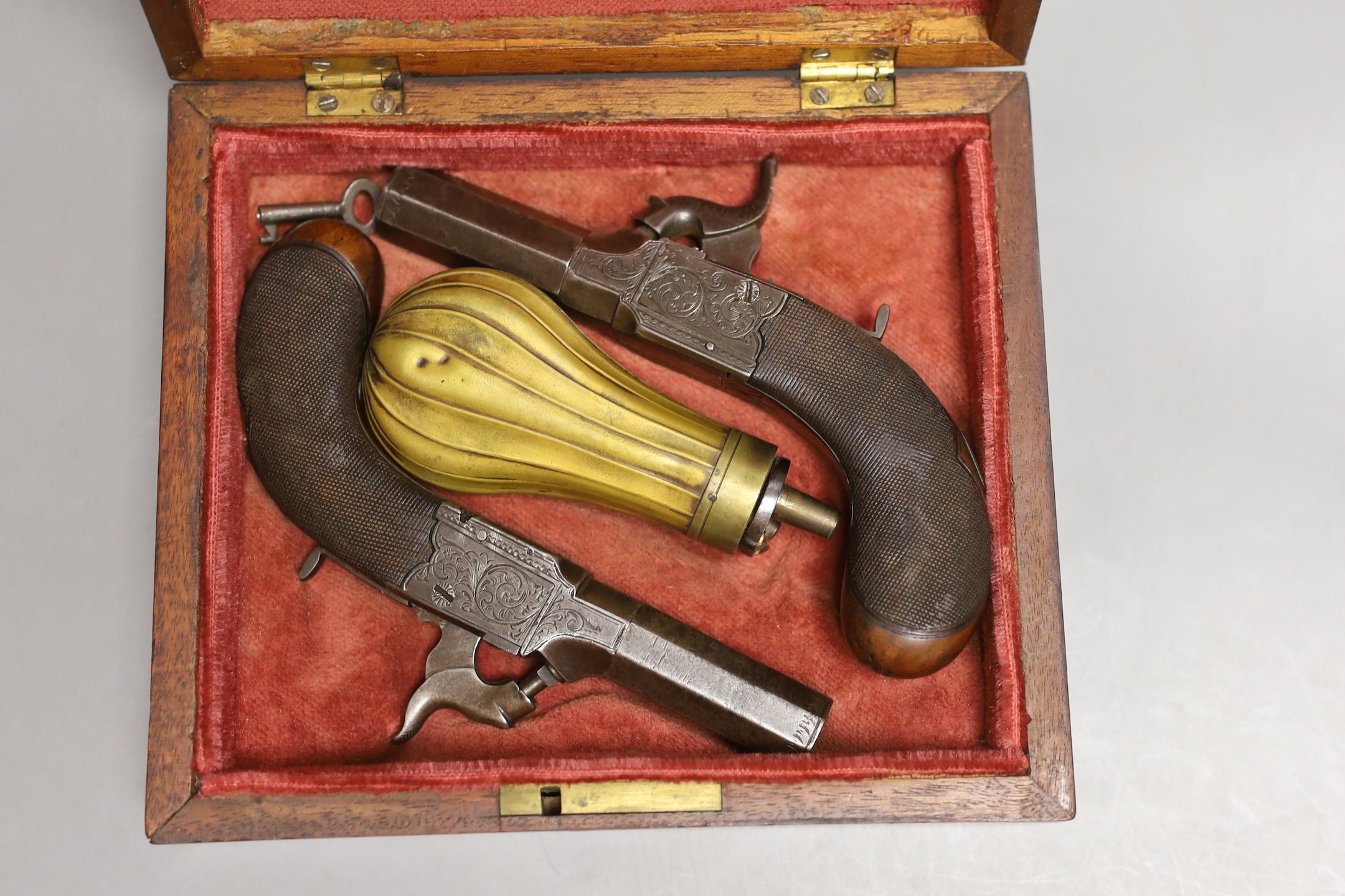A pair of muff pistols and powder flask, original fitted mahogany case and key, circa 1830